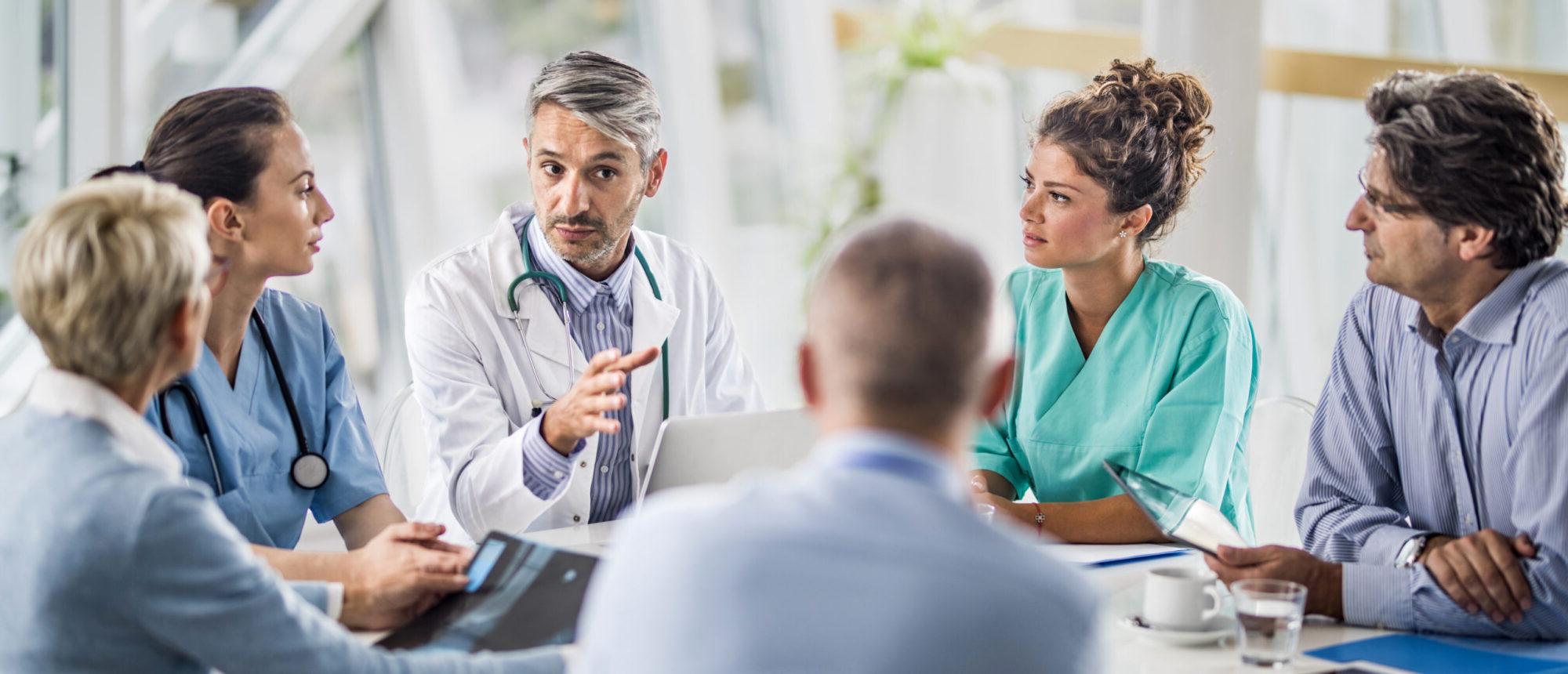 医生和他的同事在医院开会时与一组商务人士交谈.